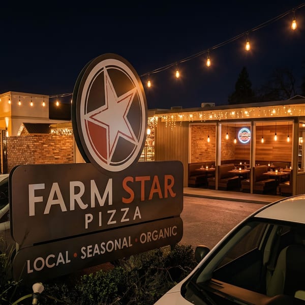 Exterior of Farm Star Pizza at night, with a large sign and illuminated outdoor seating area.